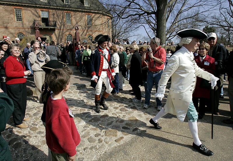 
              FILE - In this Friday March 18, 2006 file photo, visitors to Colonial Williamsburg gather in the courtyard of the Colonial Capital as they watch the Royal Governor played by, Stephen Moore, right, a historical interpreter in a program called "Revolutionary City" in Williamsburg, Va. Colonial Williamsburg, facing a decline in visitors and hundreds of millions in debt, announced Thursday, June 30, 2017 it will outsource many of its commercial operations in a restructuring that will include layoffs. (AP Photo/Steve Helber)
            