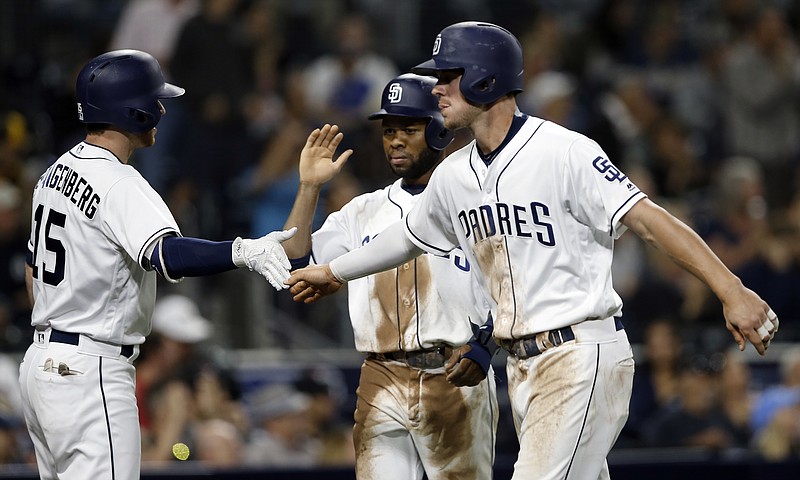 San Diego Padres' Cory Spangenberg, left, congratulates Wil Myers, right, and Manuel Margot, who scored on a triple by Hunter Renfroe during the fourth inning of the team's baseball game against the Atlanta Braves in San Diego, Wednesday, June 28, 2017. (AP Photo/Alex Gallardo)