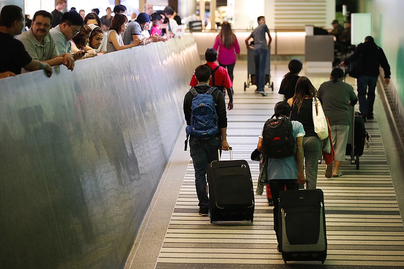 Travelers make their way up the arrival ramp at the Tom Bradley International Terminal at the Los Angeles International Airport Thursday, June 29, 2017, in Los Angeles. After months of wrangling, tighter restrictions on travel to the U.S. from six mostly Muslim nations take effect Thursday evening after the Supreme Court gave its go-ahead for a limited version of President Donald Trump's plans for a ban. (AP Photo/Jae C. Hong)