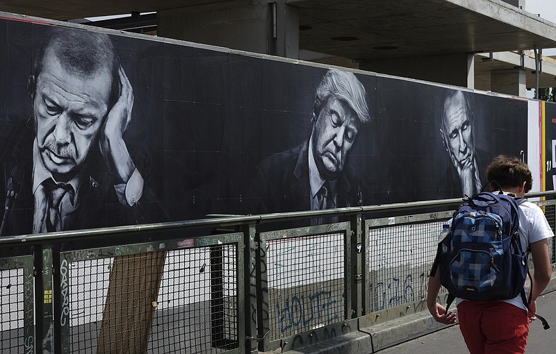
              A poster with the portraits of Turkish President, Recep Tayyip Erdogan, left, US President Donald Trump, center, and Russian President Vladimir Putin, hangs on the Warschauer  Bruecke, Warsaw Bridge,  in Berlin, Germany,  Tuesday, June 27, 2017. The poster is part of an advertisement campaign of a drinks manufacturer. (Jens Kalaene/dpa via AP)
            