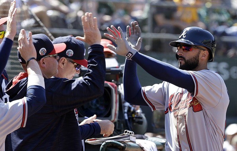 Atlanta Braves' Nick Markakis, right, is congratulated after scoring against the Oakland Athletics in the eighth inning of a baseball game Saturday, July 1, 2017, in Oakland, Calif. Markakis scored on a sacrifice fly by Braves' Matt Adams. (AP Photo/Ben Margot)