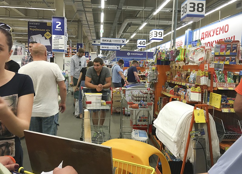 
              People queue for their turn to pay at a slowly working cash desk in a building supermarket in Kiev, Ukraine, Wednesday, June 28, 2017.  The cyberattack ransomware that has paralyzed computers across the world hit Ukraine hardest Tuesday, with victims including top-level government offices, energy companies, banks, cash machines, gas stations, and supermarkets.  (AP Photo/Efrem Lukatsky)
            