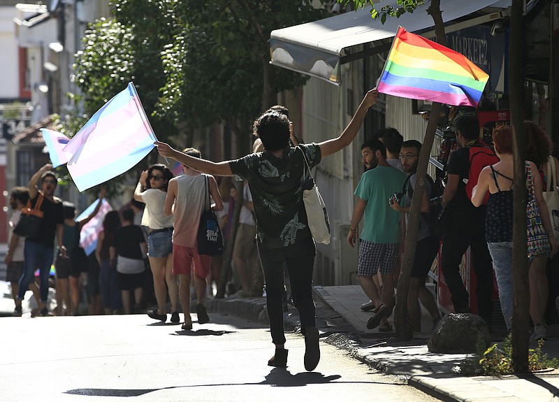 
              LGBTI activists disperse to avoid detention by Turkish police officers in Istanbul, Sunday, July 2, 2017. A small group of transgender rights activists has attempted to march to Istanbul's main square, carrying rainbow flags, despite the governor's ban and security precautions by police. The Istanbul governor's office banned the march late Saturday for the second year in a row, 'to preserve public order and to keep participants and tourists safe', it said. (AP Photo/Lefteris Pitarakis)
            