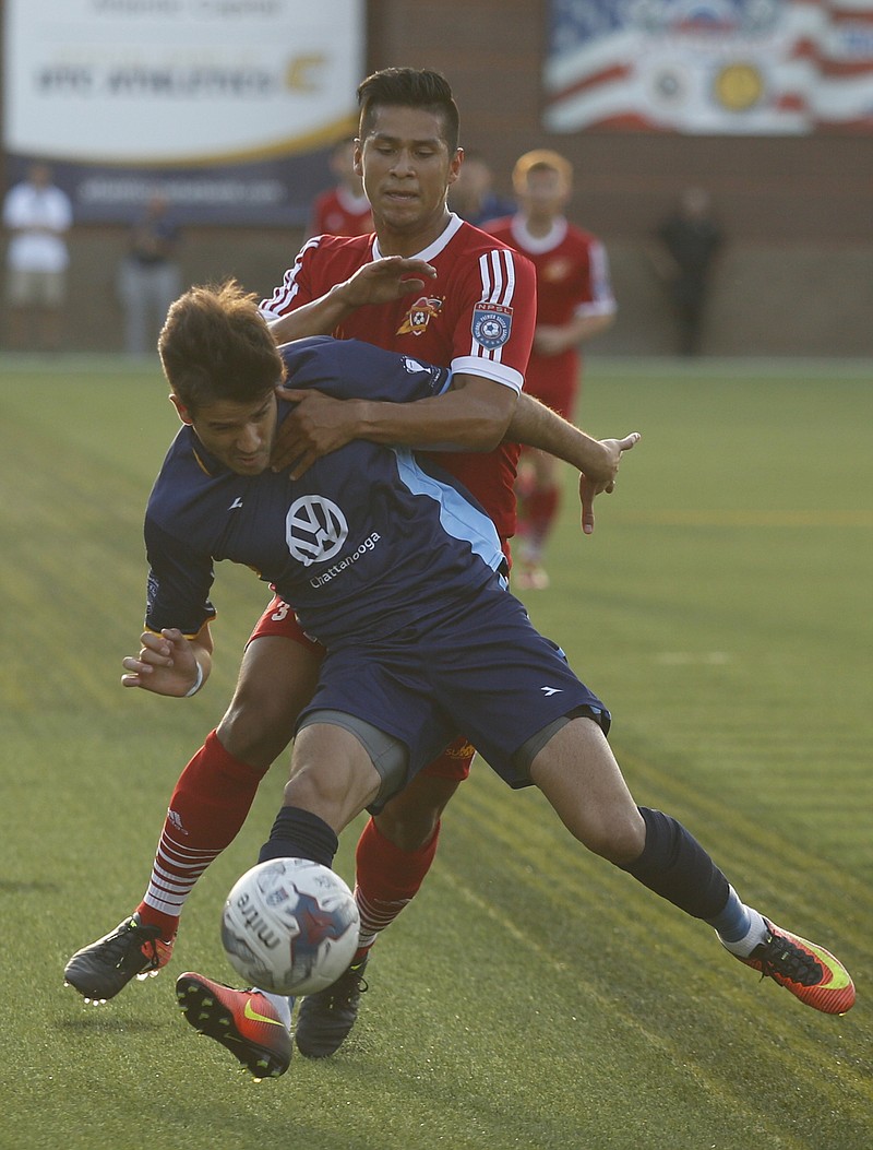 CFC's Jose Francisco Ferraz is brought down from behind by Carolina's Demetrio Andrade during Chattanooga FC's soccer match against Carolina United FC at Finley Stadium on Saturday, June 24, 2017, in Chattanooga, Tenn.