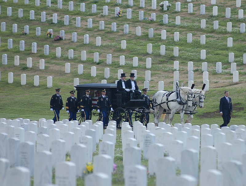 Medal of Honor recipient Desmond Doss is borne home to his final resting place in the Chattanooga National Cemetery by a horse-drawn carriage in 2006.