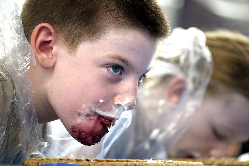 Owen Accord looks for encouragement from the crowd during the blueberry pie eating contest. It was red, white and blueberries at the Chattanooga Market to honor July Fourth on July 2, 2017.