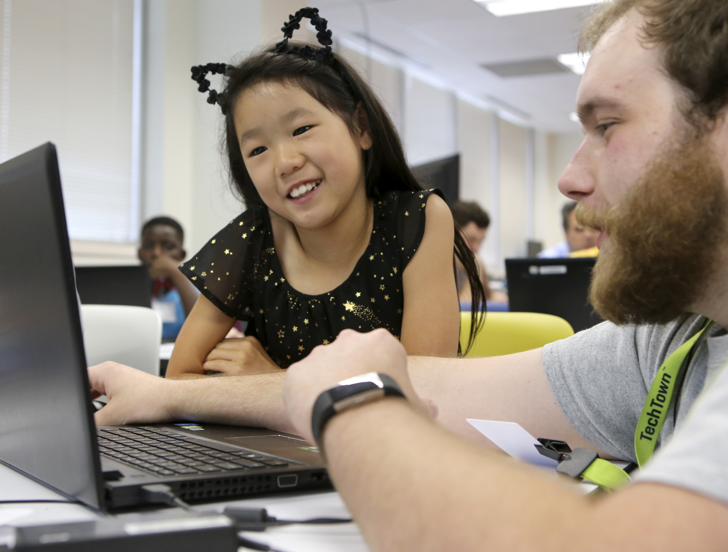 Travis Helton, a robotics and coding instructor and IT specialist, works with 10-year-old Aurea Federico on her maze during Tech Town camp at the Edeny Building on Thursday, June 29, in Chattanooga, Tenn.