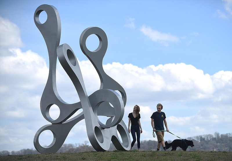 Eve Hermann and Nick York walk Caboose Thursday, Feb. 23, 2017 in Sculpture Fields at Montague Park