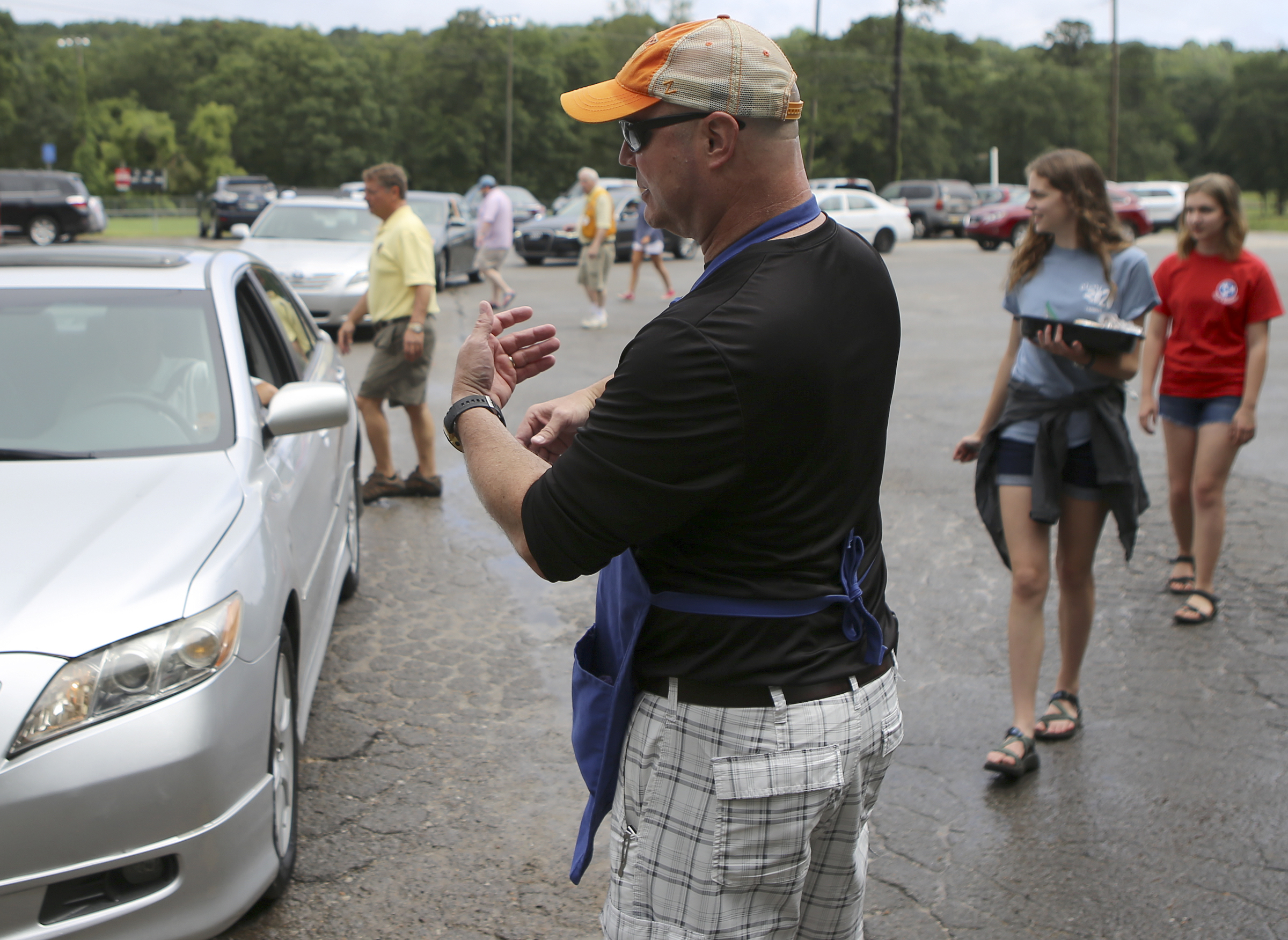 Signal Mountain Lions Club Treasurer Tom Sheets helps direct traffic in the drive-thru line during their annual Fourth of July barbecue at Althaus Park on Tuesday, July 4, in Signal Mountain, Tenn. According to club president Gary Lowder, 1,000 pounds of pork was cooked in preparation to serve about 700 patrons.