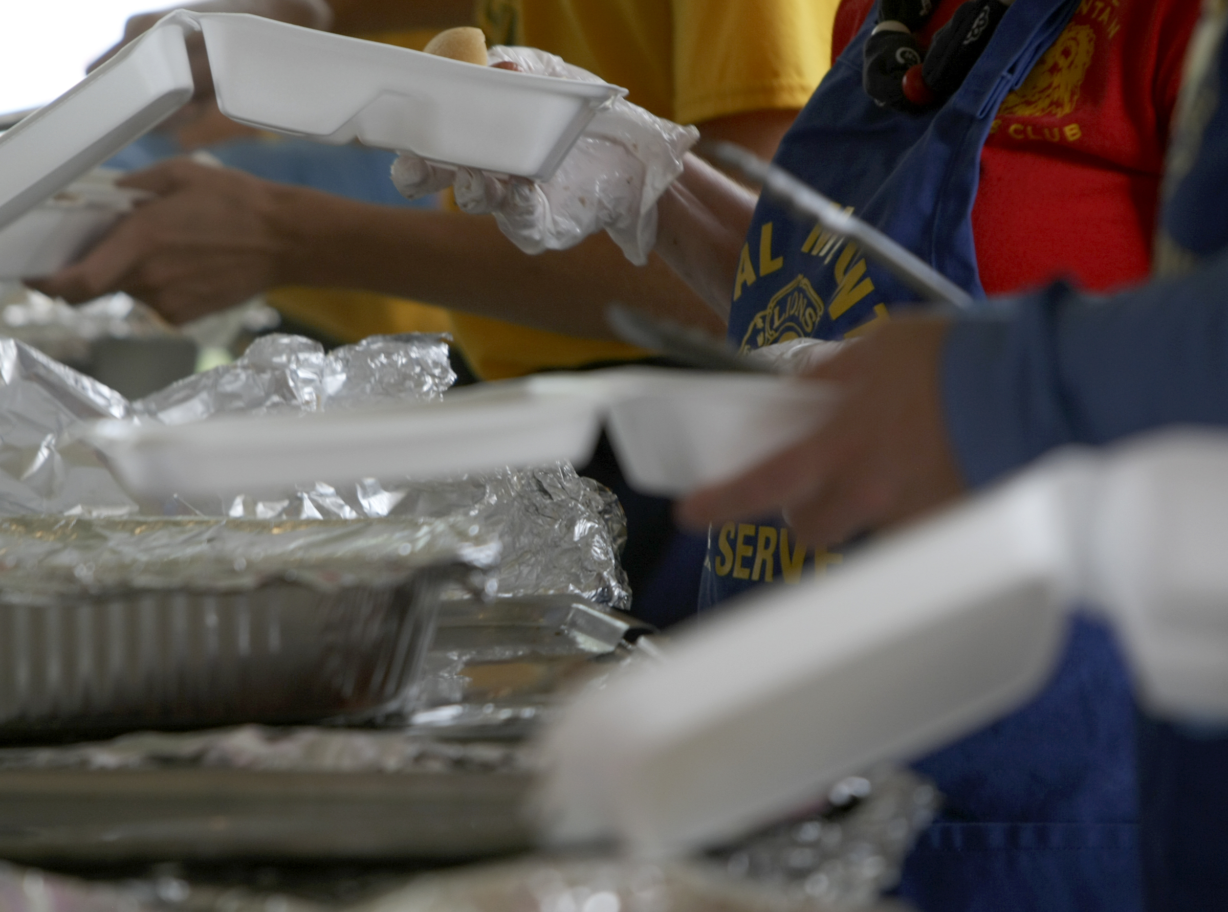 Plates are prepared during the Signal Mountain Lions Club's annual Fourth of July barbecue at Althaus Park on Tuesday, July 4, in Signal Mountain, Tenn. According to club president Gary Lowder, 1,000 pounds of pork was cooked in preparation to serve about 700 patrons.