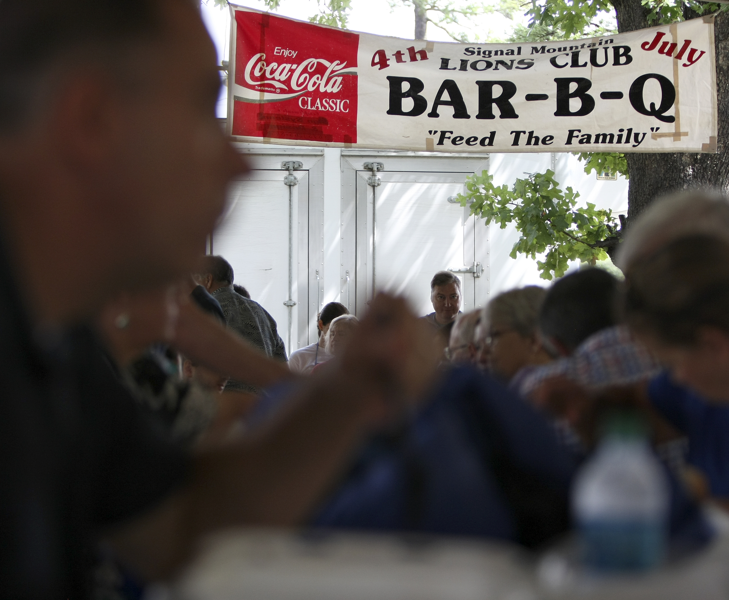 People sit underneath the pavilion during the Signal Mountain Lions Club's annual Fourth of July barbecue at Althaus Park on Tuesday, July 4, in Signal Mountain, Tenn. According to club president Gary Lowder, 1,000 pounds of pork was cooked in preparation to serve about 700 patrons.