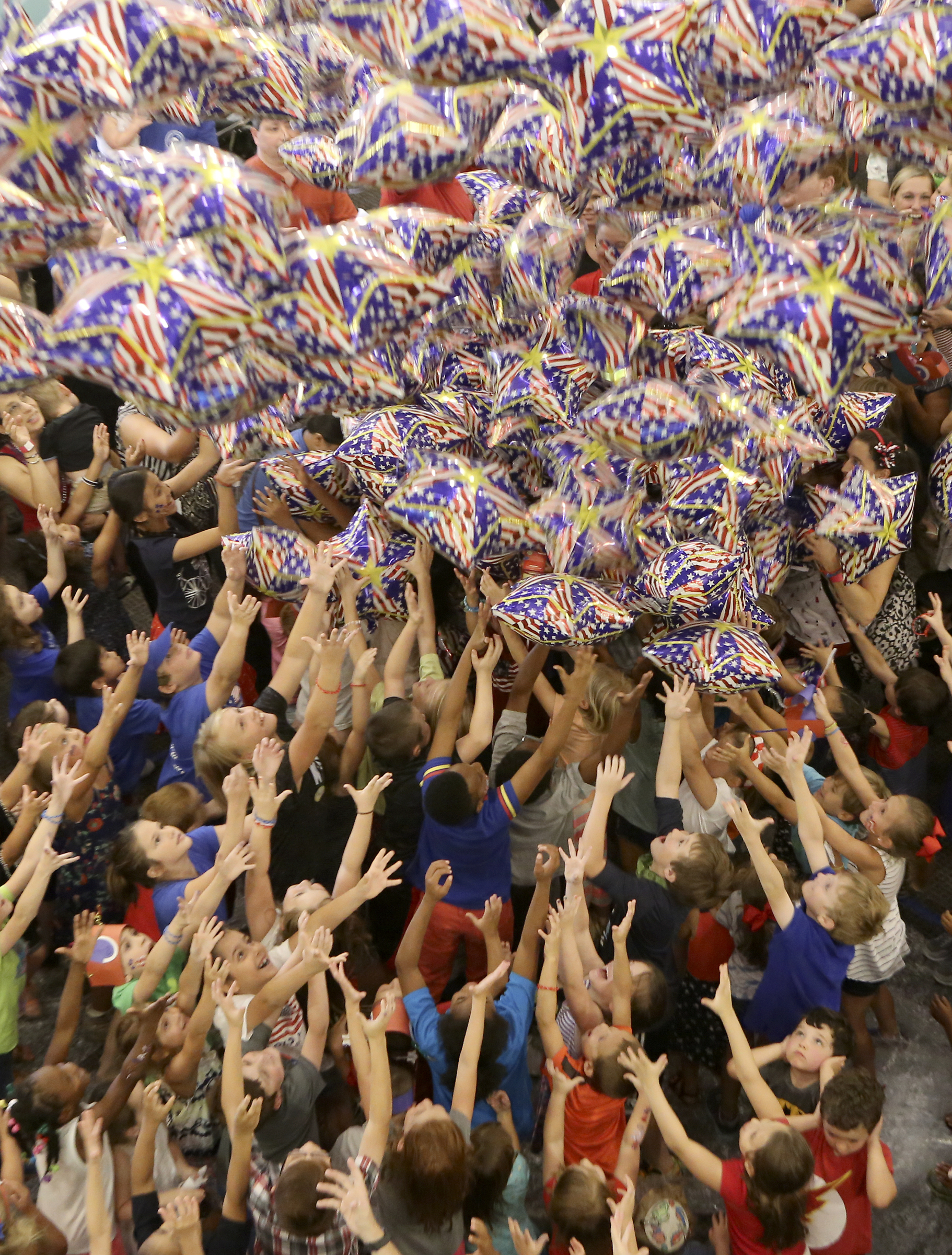 Kids reach for balloons as the fall from the ceiling in the atrium during Red, White and Blue Day at the Creative Discovery Museum on Tuesday, July 4, in Chattanooga, Tenn. The Creative Discovery Museum held their Red, White and Blue Day which included several activities like bubblewrap fireworks, a balloon drop, birthday cake and a history lesson.