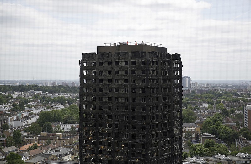 
              FILE - In this Friday, June 16, 2017 file photo, emergency workers walk on the roof of the fire-gutted Grenfell Tower in London, after a fire engulfed the 24-storey building. British authorities say they won't prosecute anyone who unlawfully sublet apartments in the west London tower block before it was devastated by fire. (AP Photo/Matt Dunham, File)
            