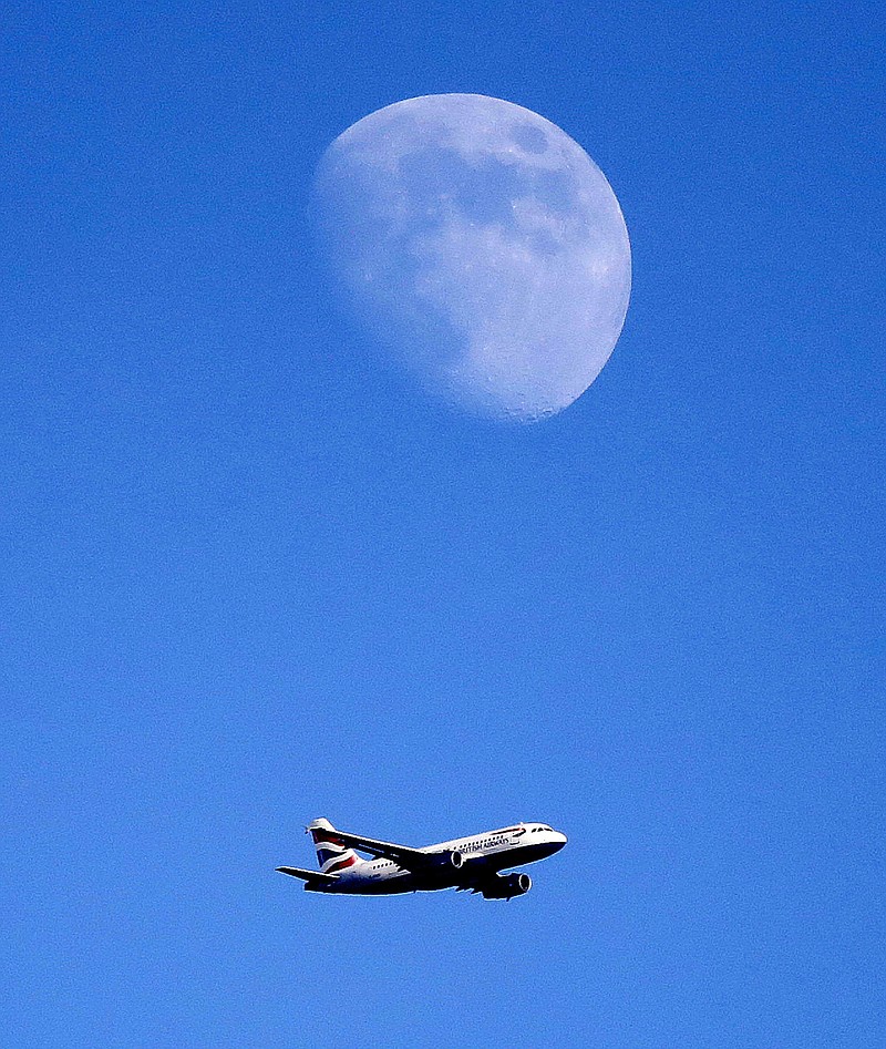 
              A British Airways plane approches landing at Heathrow Airport below the moon in London, Tuesday, July 4, 2017. (AP Photo/Frank Augstein)
            