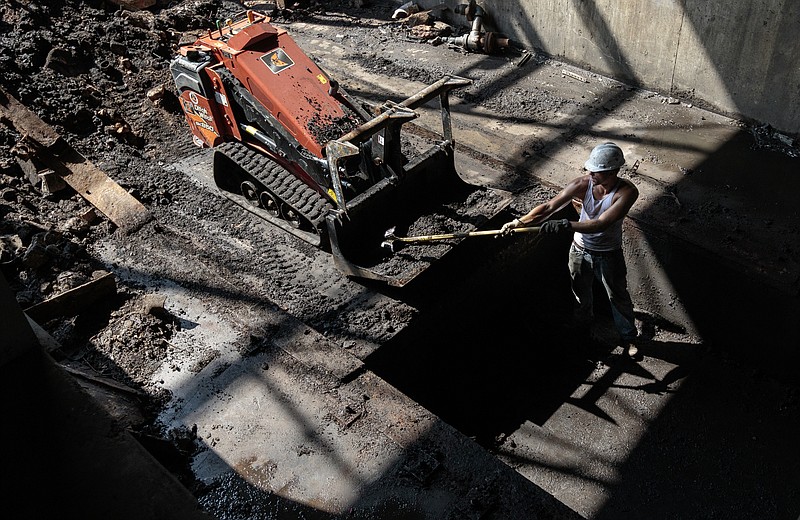 Nate Russ digs debris out of a pit that used to house Erlanger Hospital's incinerator in the building that will soon be home to the hospital's new energy plant on Wednesday, July 5, 2017, in Chattanooga, Tenn. Erlanger has begun the process of upgrading its energy plant with a more efficient system.