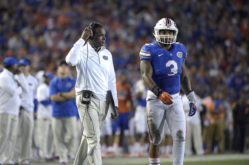Florida associate head coach Randy Shannon, left, walks onto the field with quarterback Treon Harris (3) during a timeout during the first half of an NCAA college football game against Florida State in Gainesville, Fla., Saturday, Nov. 28, 2015. (AP Photo/Phelan M. Ebenhack)