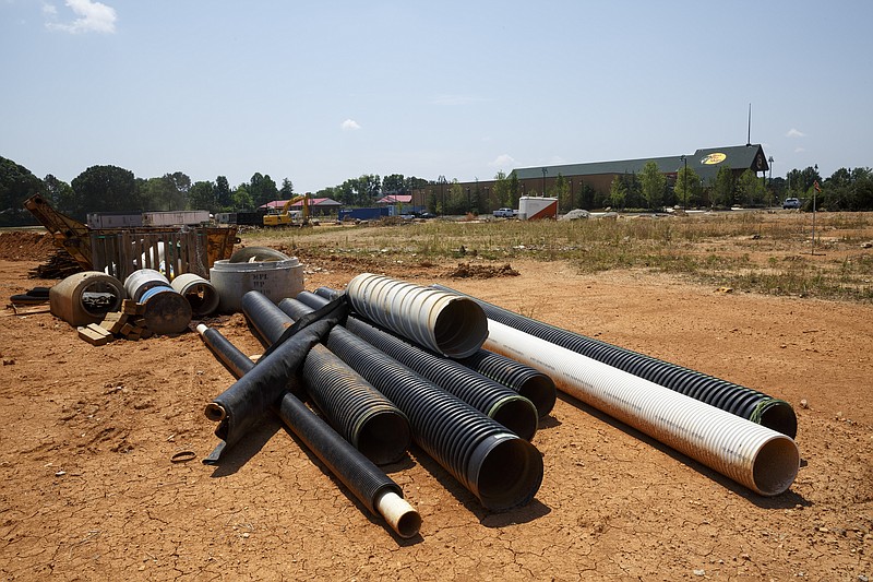 Piping waits on a cleared site adjacent to the new Bass Pro Shops location on Camp Jordan Parkway in June 2016. WWTA is eligible for a loan that will kick-start its efforts to prepare sewer infrastructure for the growth coming to the eastern part of the county.