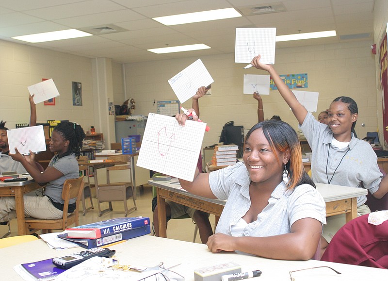Students in an advanced placement calculus class at Howard High School several years ago raise their hands during an exercise in graphing.