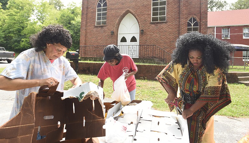 Martha Williams, Wanda Buck and Pastor Charlotte Williams, from left, sort food items for community members at Eastdale Village Community United Methodist Church on Thursday, June 9, 2016.