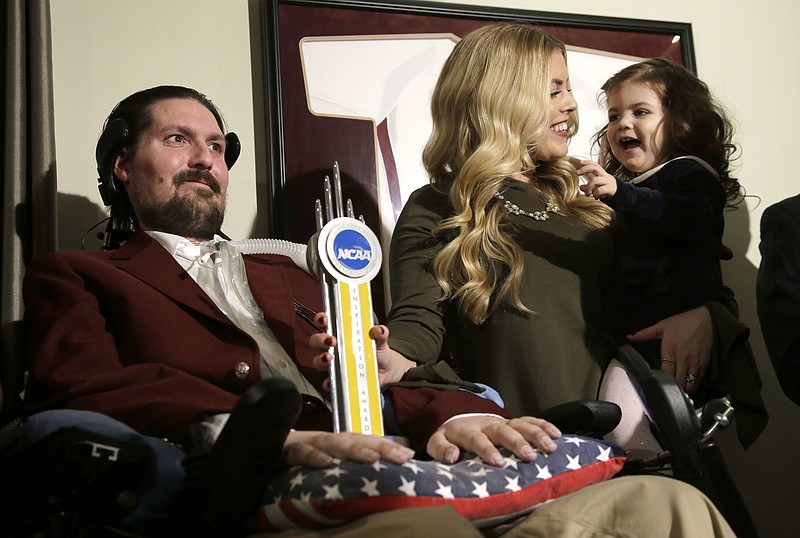 
              FILE - In this Dec. 13, 2016, file photo, former Boston College baseball captain Pete Frates, left, appears with his wife Julie, center, and two-year-old daughter Lucy, right, moments after he was presented with the 2017 NCAA Inspiration Award, at their home in Beverly, Mass. Pete Frates, the man who inspired the ice bucket challenge to raise millions of dollars for Lou Gehrig's disease research, could be released from the hospital this week, his family said. (AP Photo/Steven Senne, File)
            