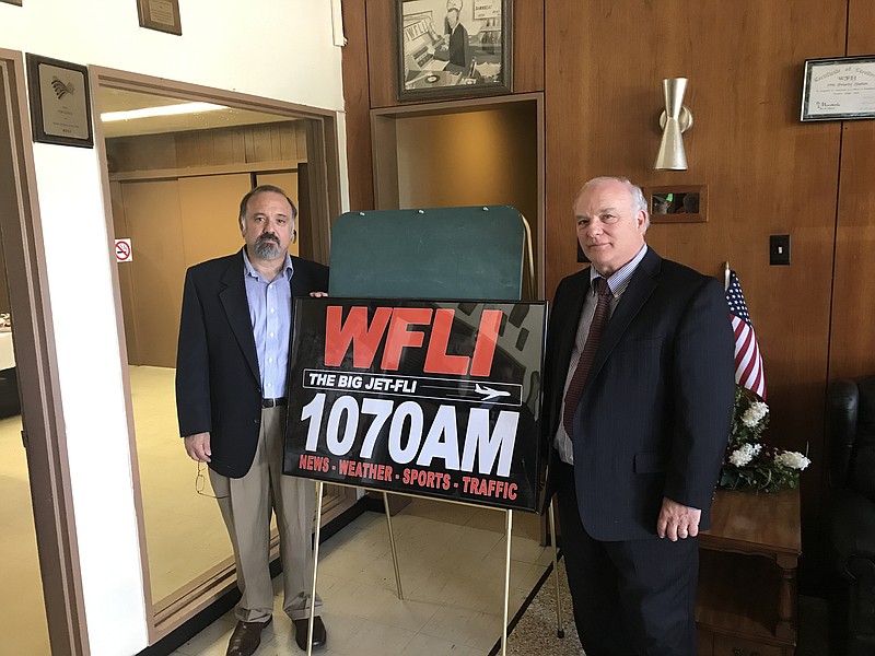 Evan Stone and Marshall Bandy reveal the new logo for WFLI-Am 1070, which they purchased recently. They are only the second owners in the station's 56-year history.