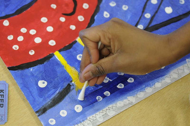 A student puts the finishing touches on a painting during an art class several years ago at Calvin Donaldson Elementary School.