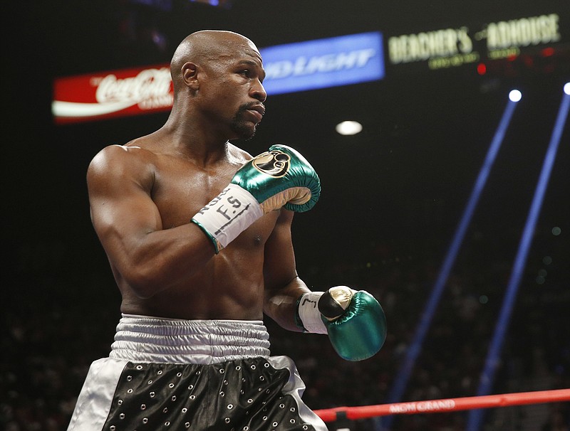 
              FILE - In this Sept. 12, 2015, file photo, Floyd Mayweather Jr. fights Andre Berto (not shown) during their welterweight title in Las Vegas. It’s still early, but give Round 1 of the trash talk battle between Conor McGregor and Mayweather Jr. to the Irish MMA star. (AP Photo/Steve Marcus, File)
            