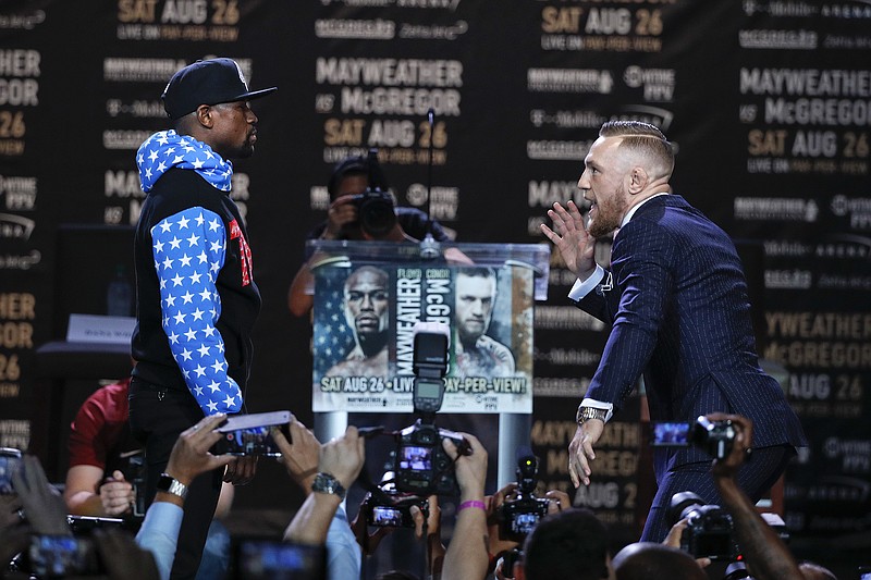 
              Conor McGregor, right, taunts Floyd Mayweather Jr. while pausing for photos during a news conference at Staples Center on Tuesday, July 11, 2017, in Los Angeles. The two will fight in a boxing match in Las Vegas on Aug. 26. (AP Photo/Jae C. Hong)
            