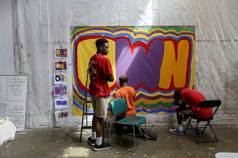 Caleb Davenport, left, Tavias Williams, center, and Jawon Young paint a mural at Mark Making's Glass Farms neighborhood studio on Friday, July 7, 2017, in Chattanooga, Tenn. Mark Making employed East Chattanooga teenagers to paint murals for the Glass Street area.