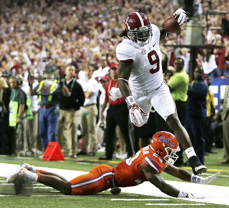 Alabama running back Bo Scarbrough (9) runs over Florida defensive back Chauncey Gardner (23) during the second half of the Southeastern Conference championship NCAA college football game, Saturday, Dec. 3, 2016, in Atlanta.(AP Photo/John Bazemore)