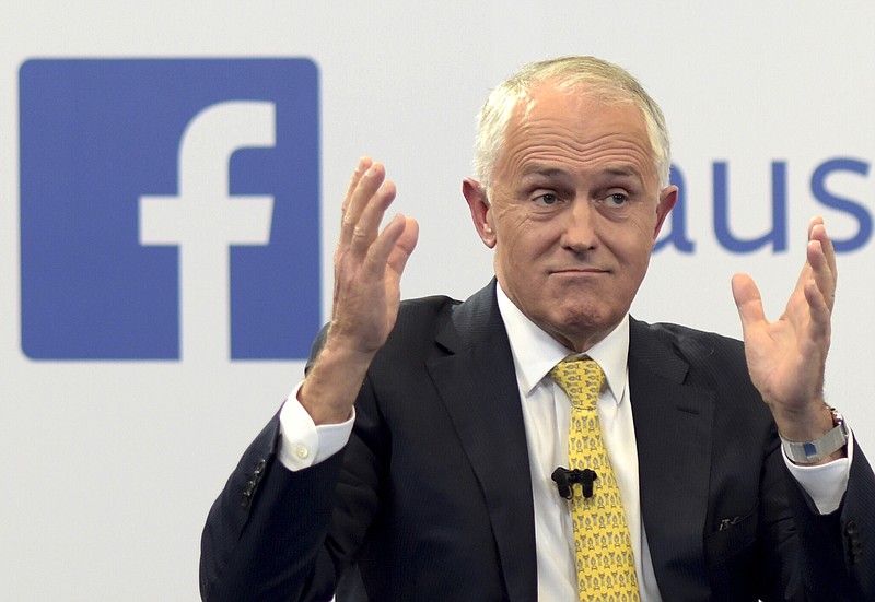 
              FILE - In this June 17, 2016 file photo, Australian Prime Minister Malcolm Turnbull raises his hands as he speaks during a leaders debate hosted by Facebook Australia and News.com.au in Sydney.  The Australian government on Friday, July 14, 2017,  proposed a new cybersecurity law to force global technology companies such as Facebook and Google to help police by unscrambling encrypted messages sent by suspected extremists and other criminals.  (Lukas Coch/Pool Photo via AP, File)
            
