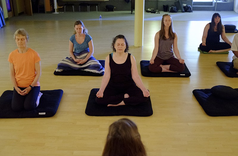 People participate in a meditation class at Clearspring Yoga on Wednesday, May 11, 2016, in Chattanooga, Tenn. Meditation is an important activity in Buddhism that helps to promote behaviors that are central to its teachings.