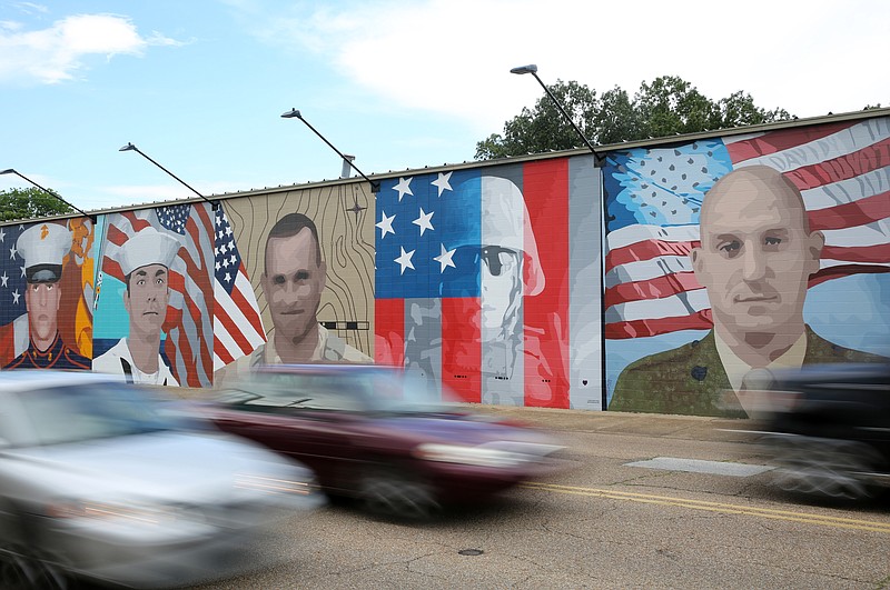 Cars drive in front of a mural for the five servicemen slain on July 16, 2015, in Chattanooga, Tenn. The mural is 22-feet tall and stretched more than 100-feet long. It took the artist Kevin Bate several gallons of paint to complete this project.