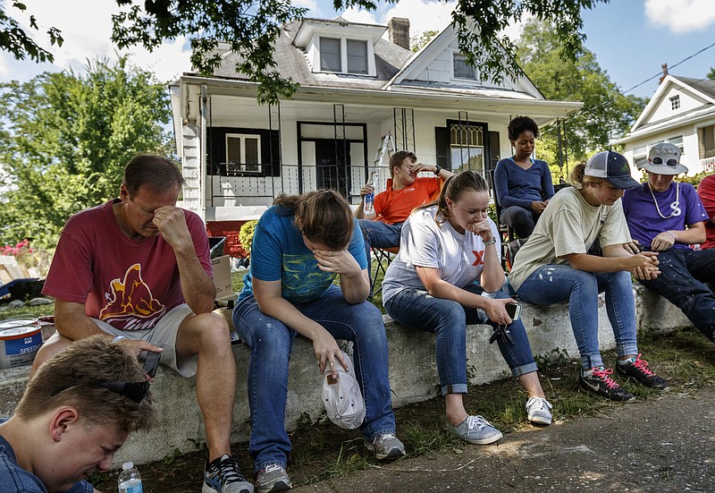 Volunteers bow their heads in prayer during a devotional in between repairing a home on Oak Street on Thursday, July 13, 2017, in Chattanooga, Tenn. Volunteers with World Changers, a student-focused mission and ministry, are in Chattanooga performing volunteer work to help area community members.