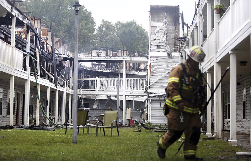 
              A firefighter walks at the scene of an apartment fire, Saturday, July 15, 2017 in Chesapeake, Va.  A fire at a senior living complex in Chesapeake, Virginia, has injured four people, including a firefighter. The fire happened early Saturday morning at Chesapeake Crossing Senior Community Apartments. Chesapeake Fire Capt. Lawrence Matthews says three residents and one firefighter were taken to a local hospital. (Steve Earley /The Virginian-Pilot via AP)
            