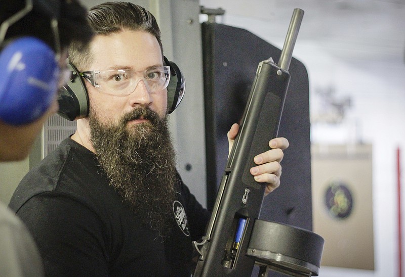 
              In this July 2, 2017 photo, Ian Usry, a former jet engine mechanic with the U.S. Navy, who works at the Knoxville Gun Range, instructs a visitor to the range, in Knoxville, Tenn. (Adam Taylor Gash/Tennessee Ledger via AP)
            