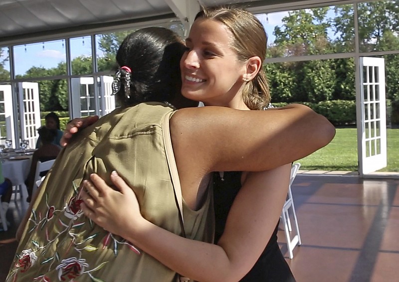 
              Janice Williamson-Cox, from Dayspring, left, hugs Sarah Cummins as she and others arrive at the Ritz Charles to enjoy a reception, Saturday, July 15, 2017. Cummins called off her wedding which was supposed to be this day. She decided to bring purpose to the couple's pain by inviting area homeless to enjoy the reception. (Kelly Wilkinson/The Indianapolis Star via AP)
            