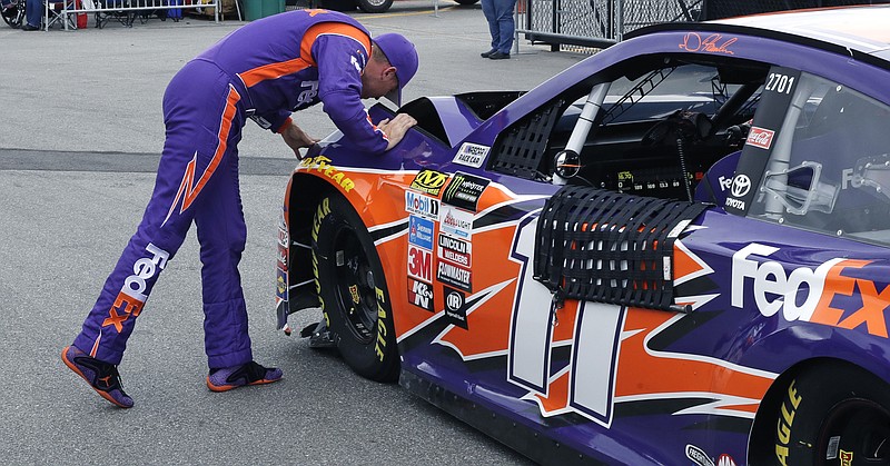 Driver Denny Hamlin examines his car after hitting the wall during a NASCAR auto racing practice at the New Hampshire Motor Speedway in Loudon, N.H., Friday, July 14, 2017. (AP Photo/Charles Krupa)