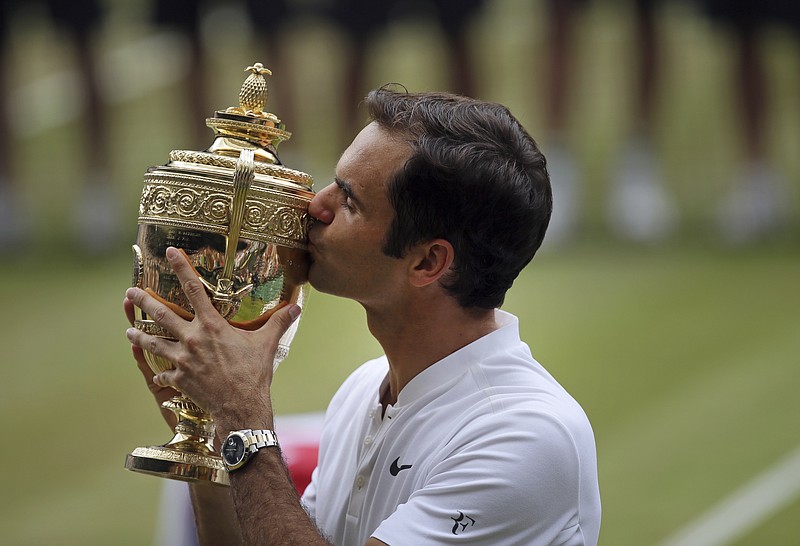 Switzerland's Roger Federer celebrates with the trophy after beating Croatia's Marin Cilic in the Men's Singles final match on day thirteen at the Wimbledon Tennis Championships in London Sunday, July 16, 2017. (AP Photo/Tim Ireland)