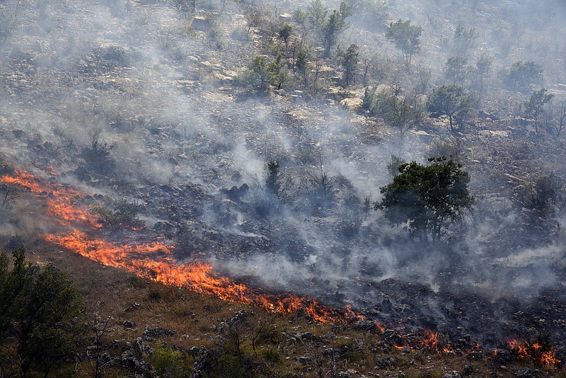 
              Smoke rises from trees burned by wildfire on a mountain near Montenegro capital Podgorica, Monday, July 17, 2017. At least 100 tourists have been forced to evacuate from a coastal area in Montenegro that has been the hardest hit by the blaze. Fueled by strong winds and dry weather, the fire on the Lustica peninsula in southern Montenegro has spread near to homes and camping zones. (AP Photo/Risto Bozovic)
            