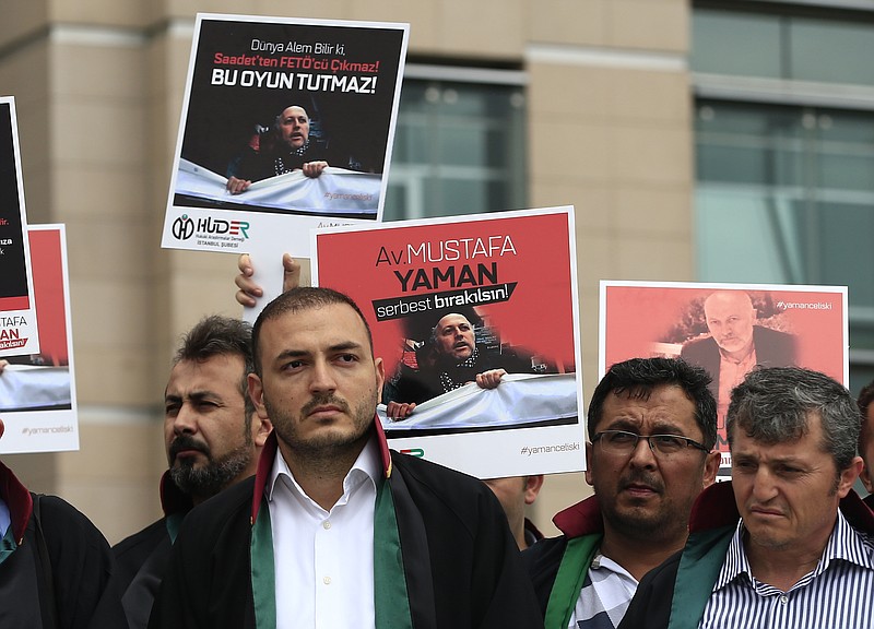 
              Turkish lawyers hold a protest outside Istanbul's court, Monday, July 17, 2017, demanding the release of Mustafa Yaman, a lawyer who according to Turkish media was detained earlier this month on suspicion of links to U.S.-based Muslim cleric Fethullah Gulen, accused by Turkey of masterminding last year's failed coup. Turkey has arrested more than 50,000 people in a large-scale crackdown launched after the failed coup attempt. (AP Photo/Lefteris Pitarakis)
            