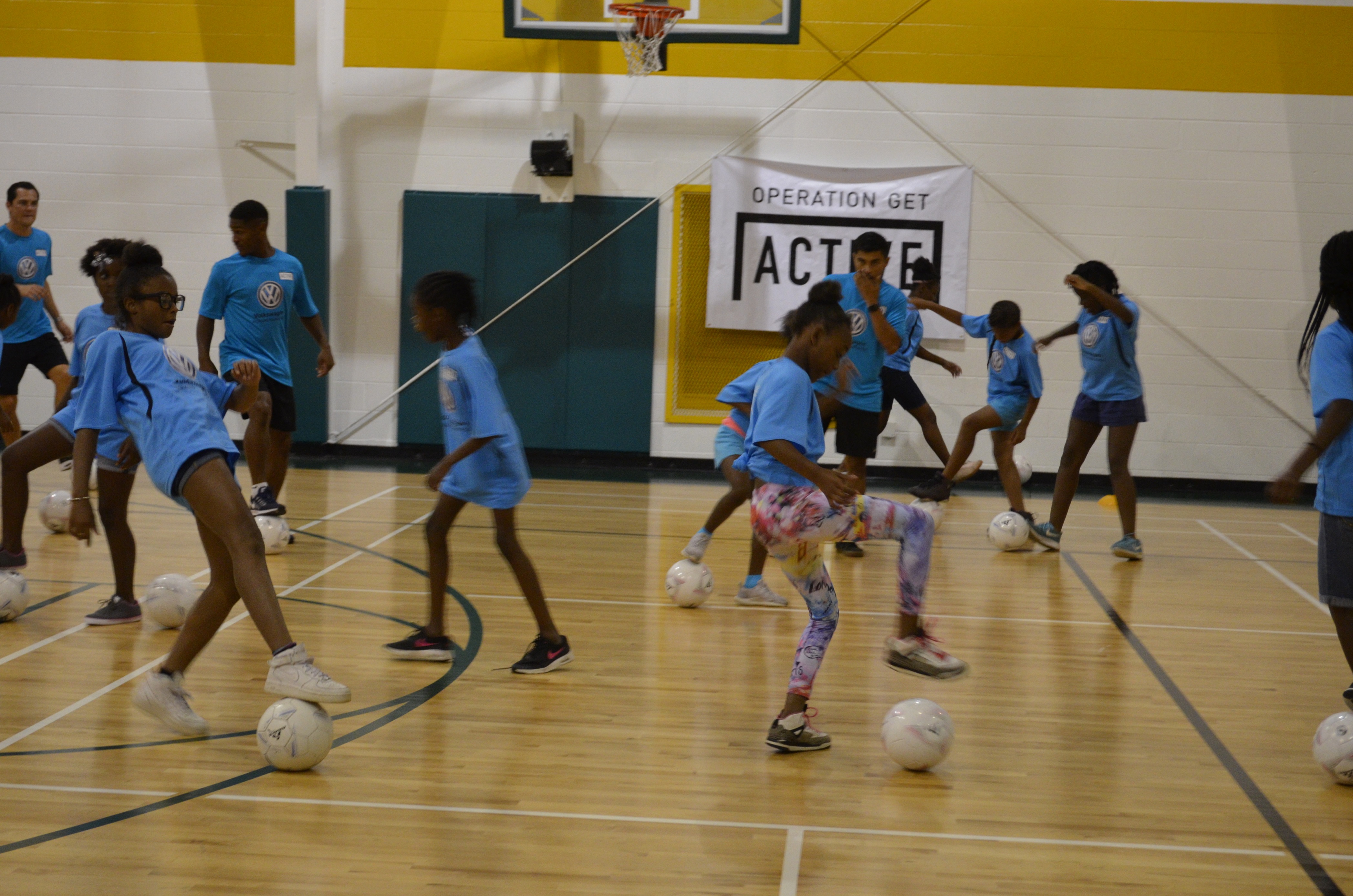 Girls at the Shepherd Youth and Family Development Center learn a toe tap exercise to help with ball control, taught by coaches from the Chattanooga Football Club's Operation Get Active.