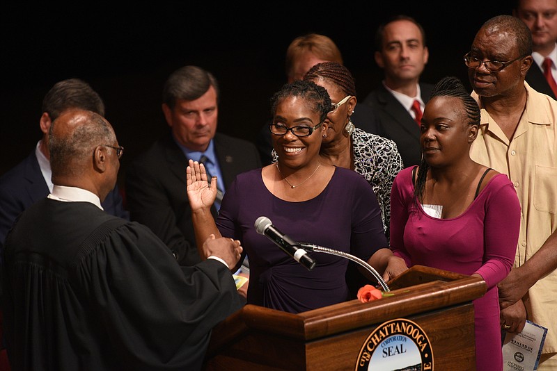 Demetrus Coonrod takes the oath of office as a city councilwoman from federal Judge Curtis L. Collier, left, in April.