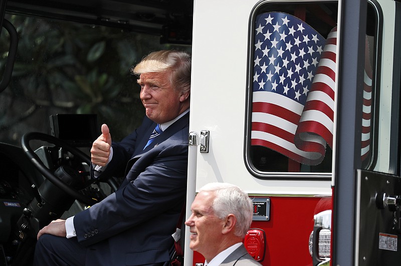 
              President Donald Trump, accompanied by Vice President Mike Pence, gives a thumbs-up, from the cabin of a Pierce firetruck during a "Made in America," product showcase featuring items created in each of the U.S. 50 states, Monday, July 17, 2017, at the White House in Washington. (AP Photo/Alex Brandon)
            