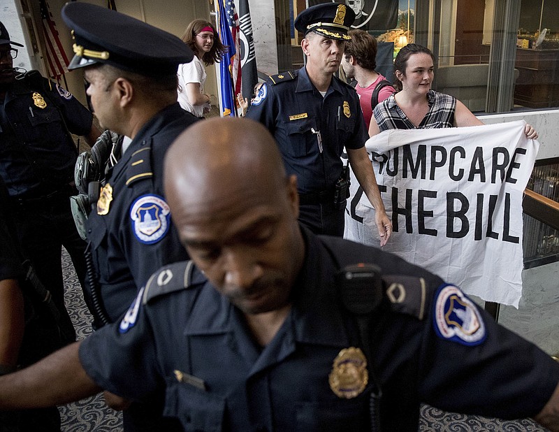 
              Capitol Hill police officers prepare to arrest a group protesting the republican healthcare bill outside the offices of Sen. Dean Heller, R-Nev., on Capitol Hill in Washington, Monday, July 17, 2017. The Senate has been forced to put the Republican's health care bill on hold for as much as two weeks until Sen. John McCain, R-Ariz., can return from surgery. (AP Photo/Andrew Harnik)
            