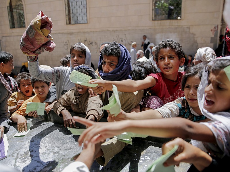 
              FILE - In this April 13, 2017, file photo, Yemenis present documents in order to receive food rations provided by a local charity, in Sanaa, Yemen. Eight of the largest U.S.-based aid groups are joining together in a new campaign to address what the United Nations calls the world's largest humanitarian crisis in more than 70 years. More than 20 million people are at risk of famine in nine African nations and Yemen, but Richard Stearns, president of Federal Way, Washington-based World Vision, says it has been overshadowed amid the controversies surrounding President Donald Trump's administration. (AP Photo/Hani Mohammed, File)
            