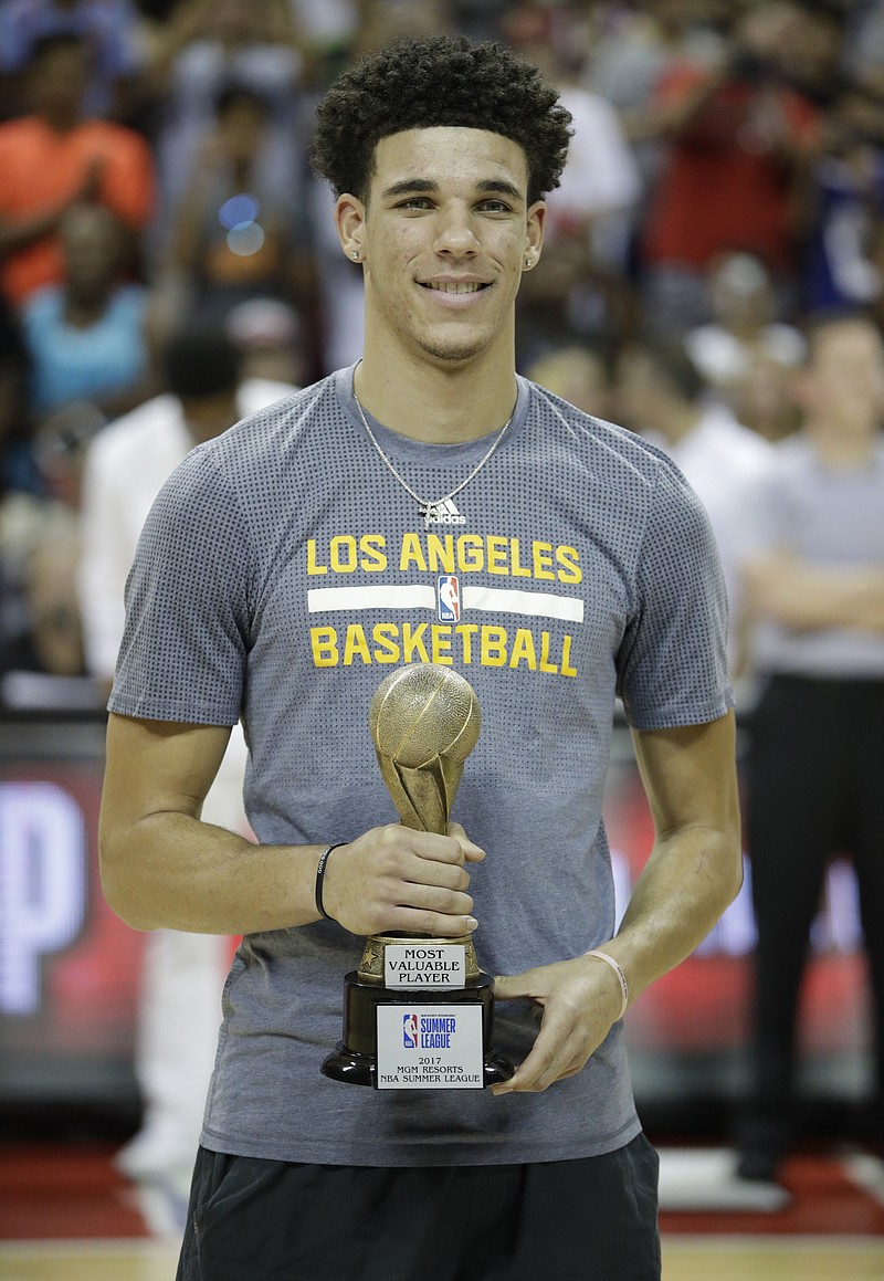 
              Los Angeles Lakers' Lonzo Ball holds up the trophy for the most valuable player in the NBA summer league, before the team's basketball game against the Portland Trail Blazers, Monday, July 17, 2017, in Las Vegas. (AP Photo/John Locher)
            