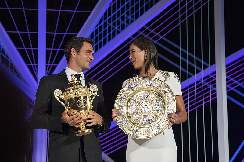 
              The 2017 Wimbledon singles champions Roger Federer of Switzerland and Garbine Muguruza of Spain pose with their trophies at the Champions Dinner at The Guildhall in London, early Monday July 17, 2017. (Thomas Lovelock/AELTC, Pool via AP)
            