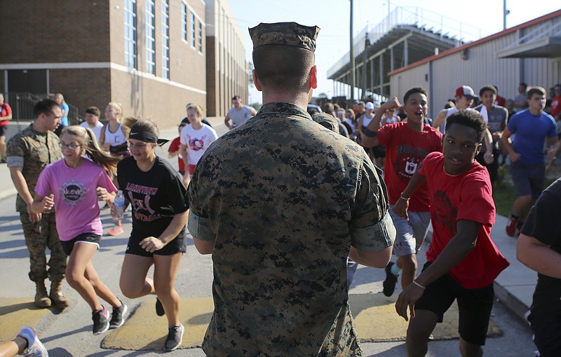 LFO athletes rush past U.S. Marine Sgt. Joseph Garcia towards a practice field at Lakeview-Fort Oglethorpe High School for a boot camp on Tuesday, July 18, in Fort Oglethorpe, Ga. Coaches and athletes from almost every sport at LFO participated in the boot camp led by the U.S. Marines.