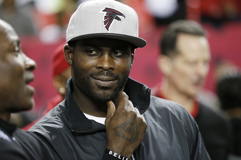 
              FILE - In this Jan. 1, 2017, file photo, former Atlanta Falcons quarterback Michael Vick stands on the sidelines before NFL football game between the Falcons and the New Orleans Saints in Atlanta. Vick told Fox Sports 1 Monday, July 17, 2017, that former San Francisco 49ers quarterback Colin Kaepernick should get a haircut in order to "try to be more presentable" as he searches for another NFL job. (AP Photo/John Bazemore, File)
            